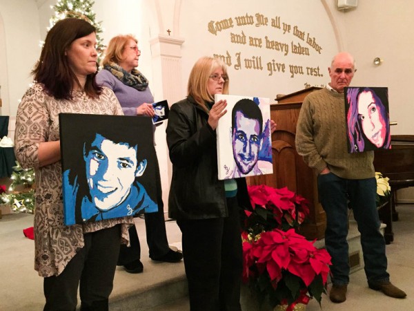 Amanda Jordan, Diane Yelle and Jim Zanfagna hold portraits of their children killed by overdoses at a service for families affected by addiction at the First Baptist Church of Plaistow on Dec. 20, in Plaistow, N.H. Anne Marie Zanfagna stands in the back. Tamara Keith/NPR